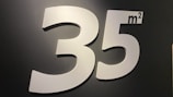 The image shows a large, prominently displayed number 35 followed by a superscript m², indicating square meters, against a dark background. The numbers and letters are in a clean, sans-serif font and appear to be in a glossy white material.