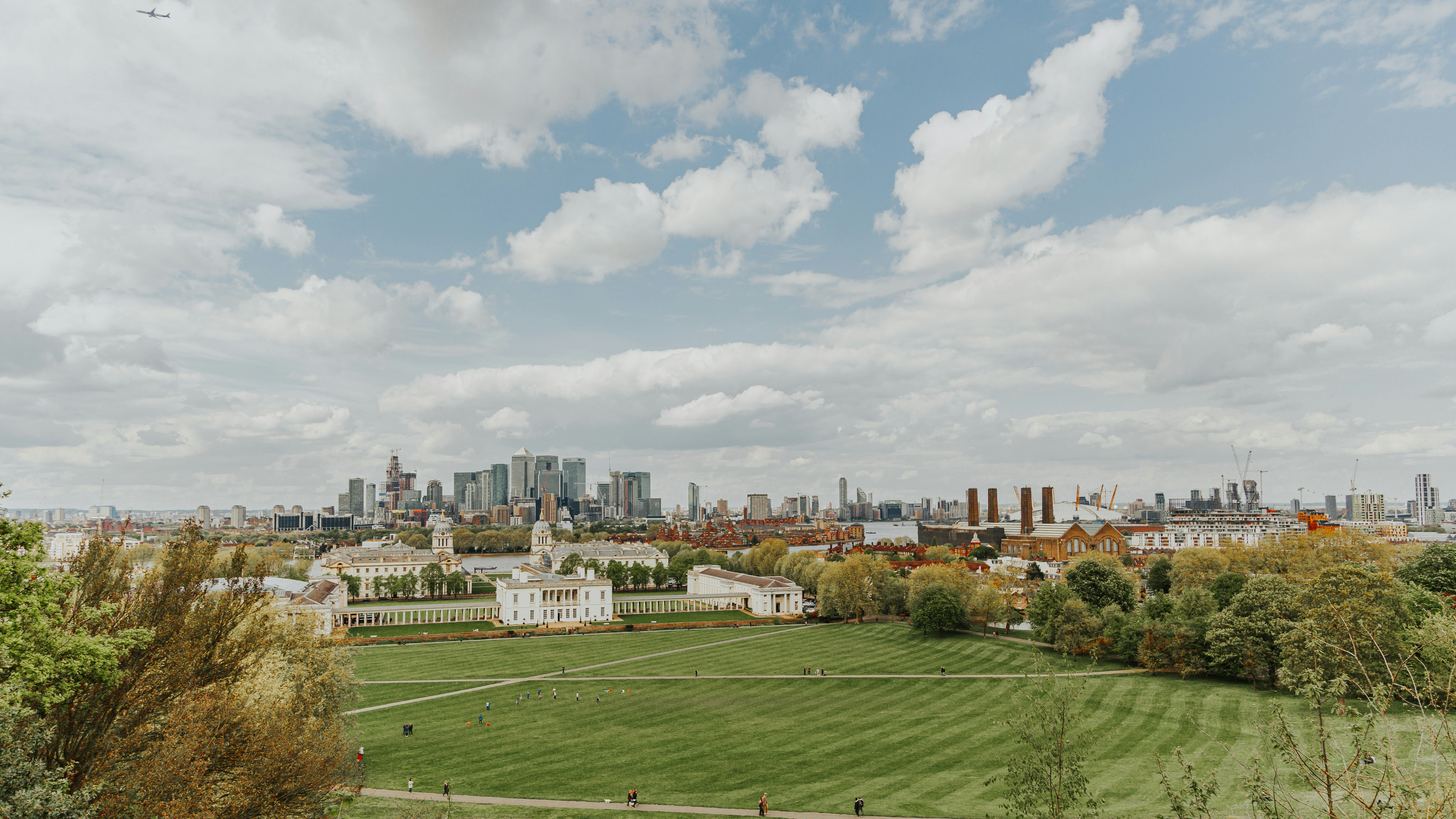 brown and white concrete buildings under white clouds and blue sky during daytime