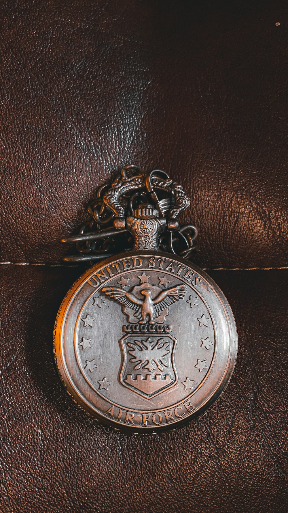 silver round coin on brown leather textile