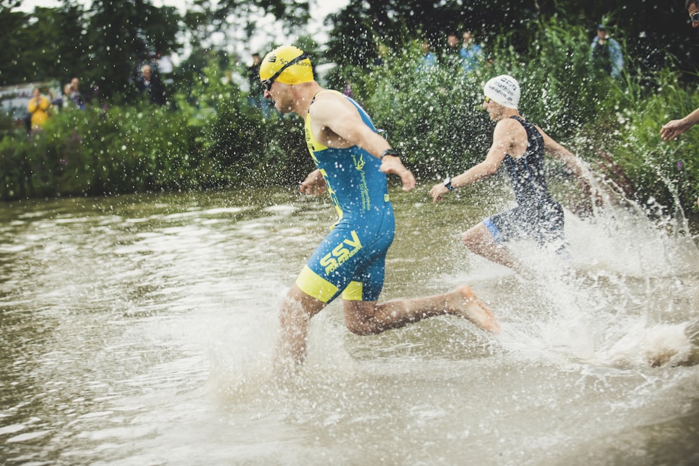 man in blue shorts running on water during daytime