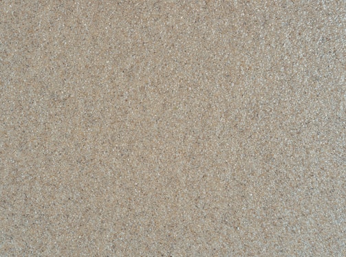 Close-up of fine, golden Australian silica sand grains sparkling under natural light.
