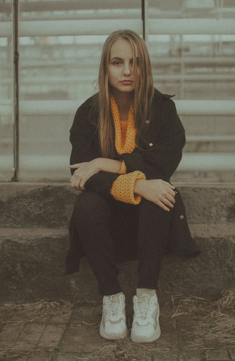 woman in black blazer and black pants sitting on concrete bench