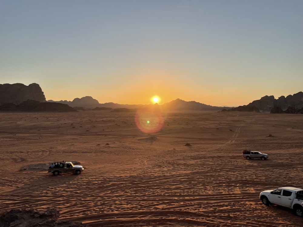 cars on desert during sunset