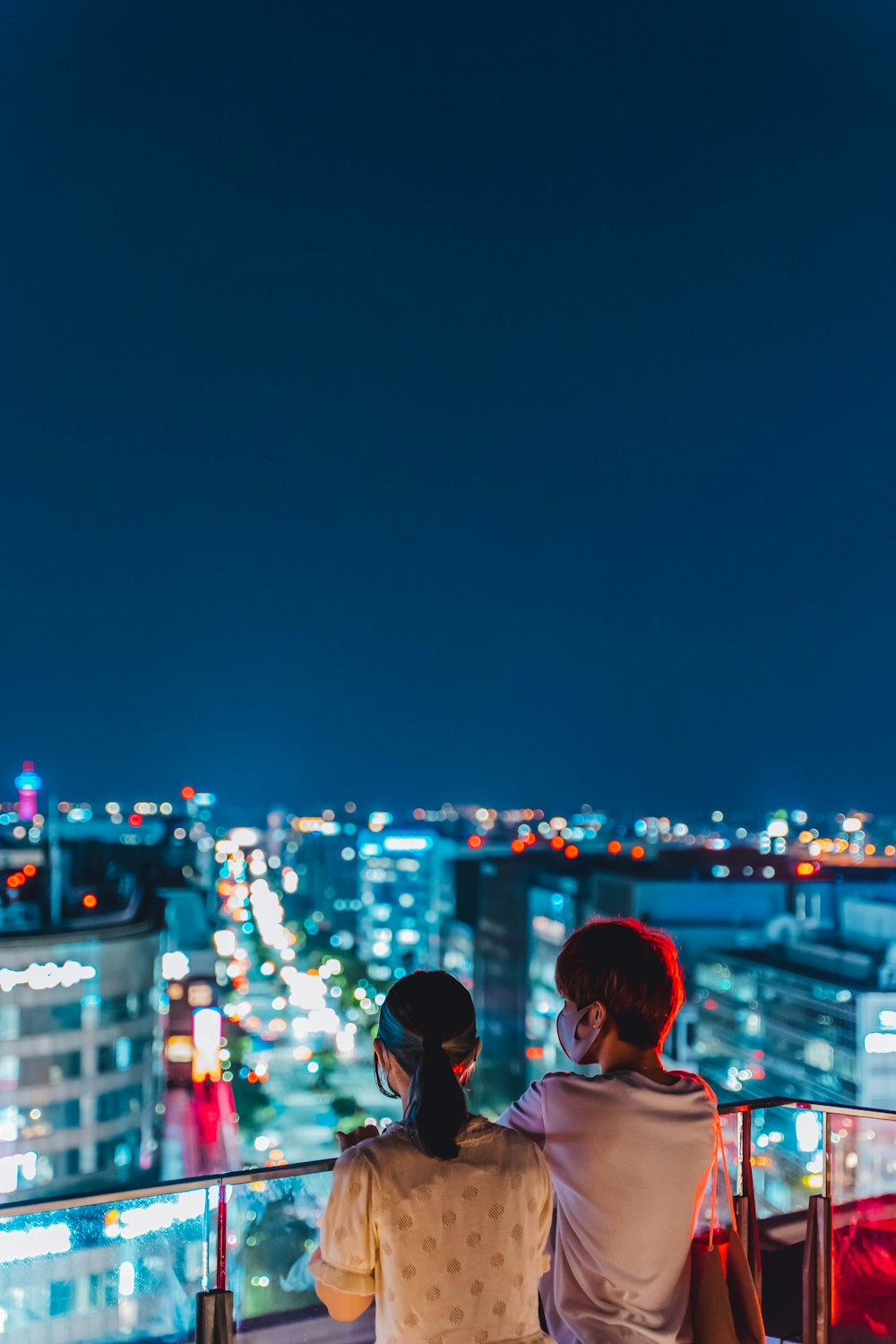 夜の街に立つ白いシャツの女性