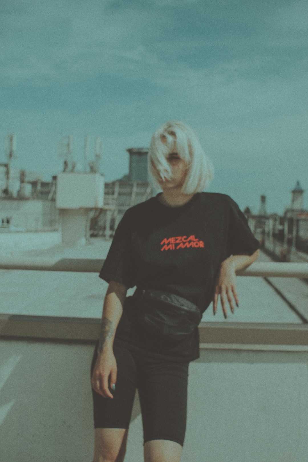 woman in black crew neck t-shirt and black skirt standing beside white metal railings during