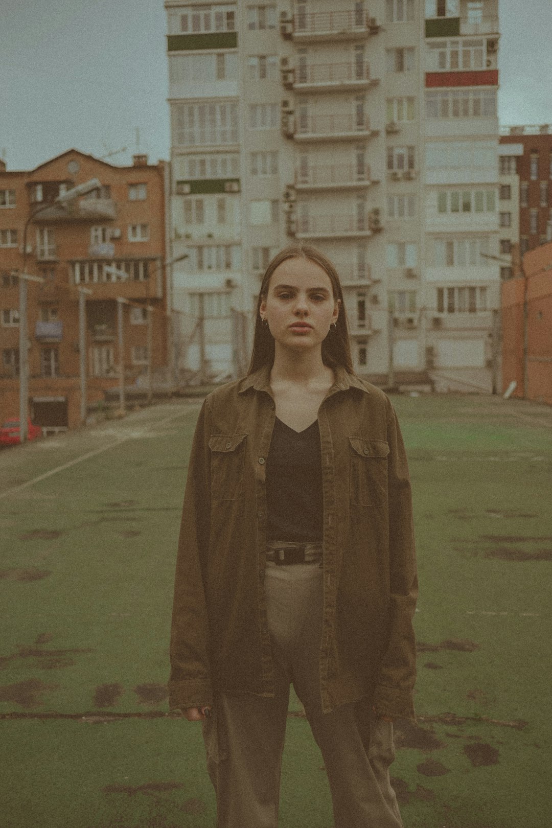 woman in brown coat standing on green grass field during daytime