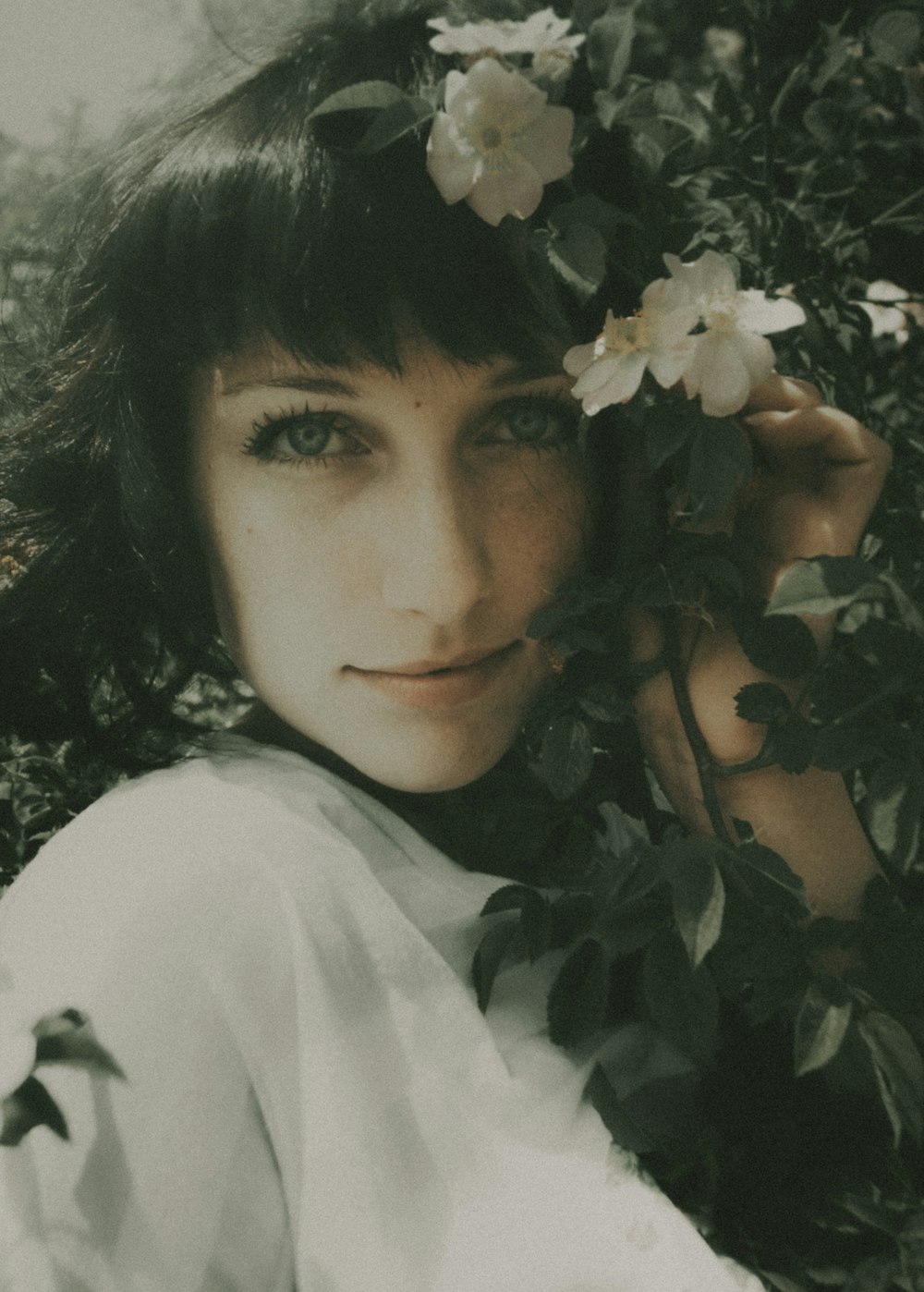 woman in white shirt standing beside white flowers