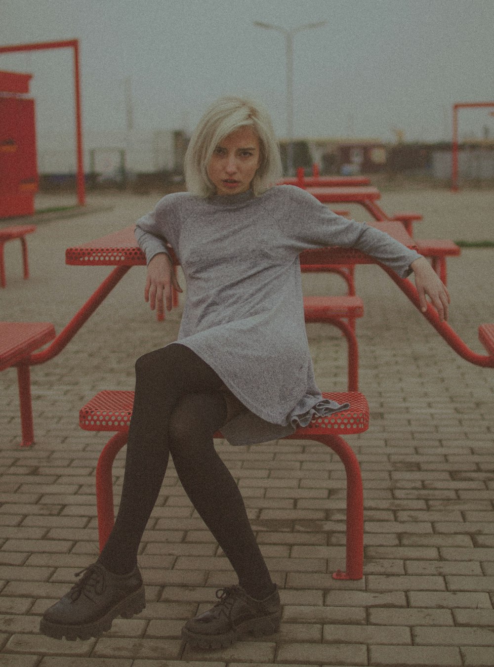 a woman sitting on a bench in a parking lot