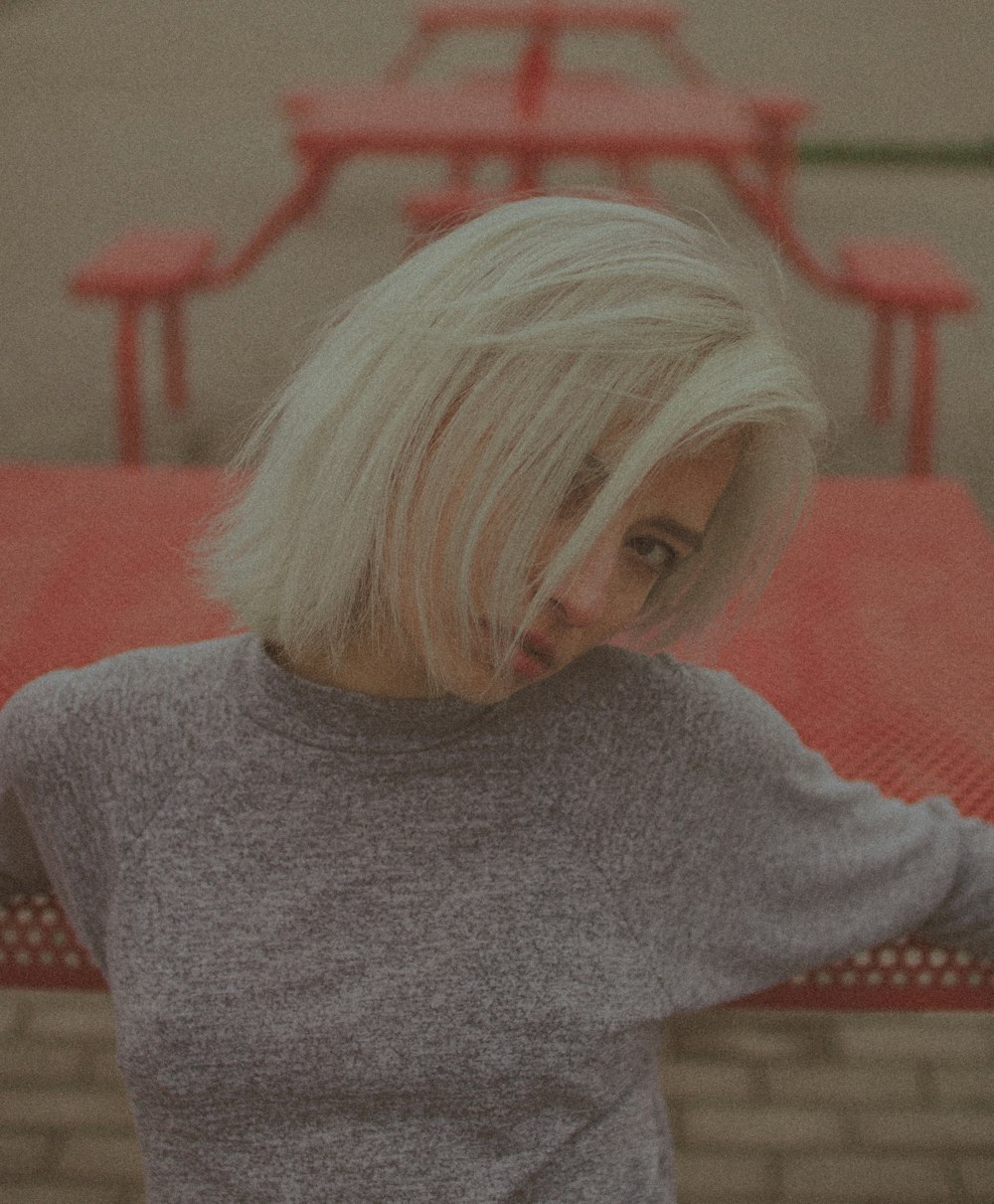 woman in gray sweater sitting on red couch