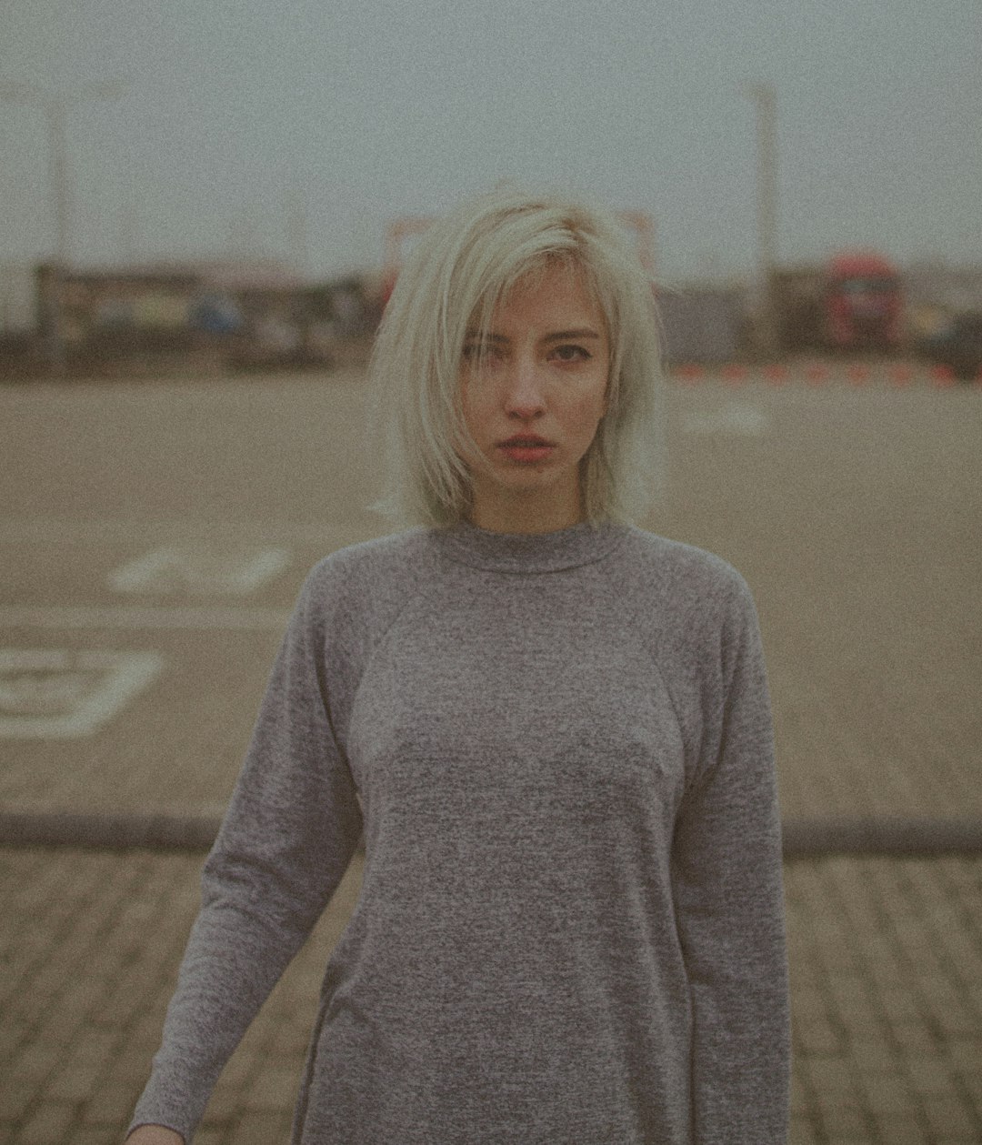 woman in gray turtleneck sweater standing on brown field during daytime