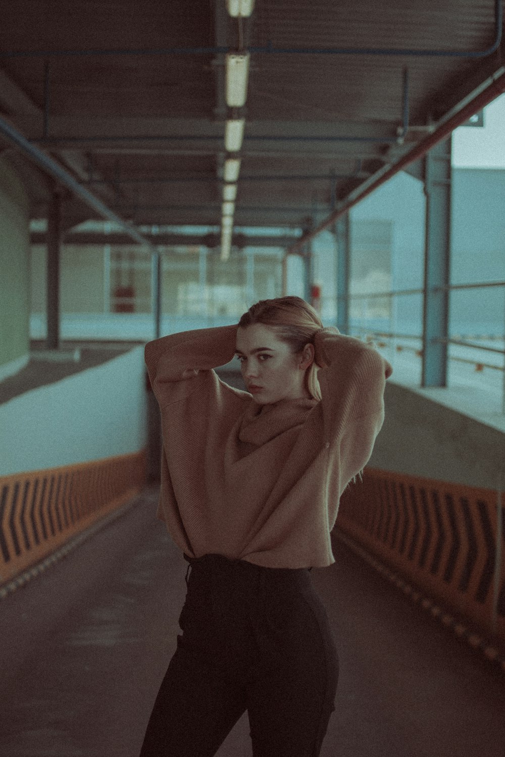 woman in brown sweater and black skirt standing on blue and orange stadium