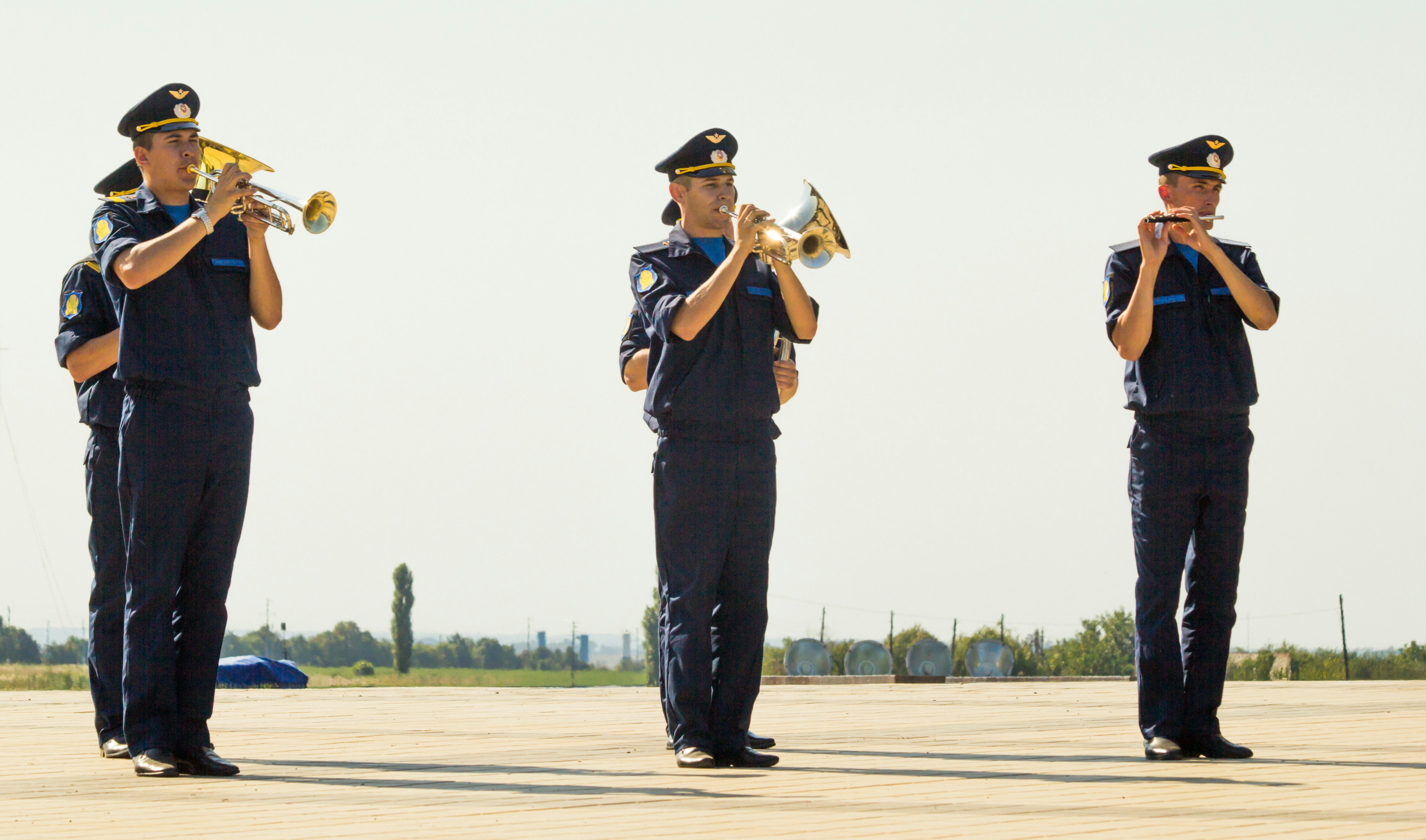 Homme en chemise et pantalon noirs debout sur le terrain pendant la journée