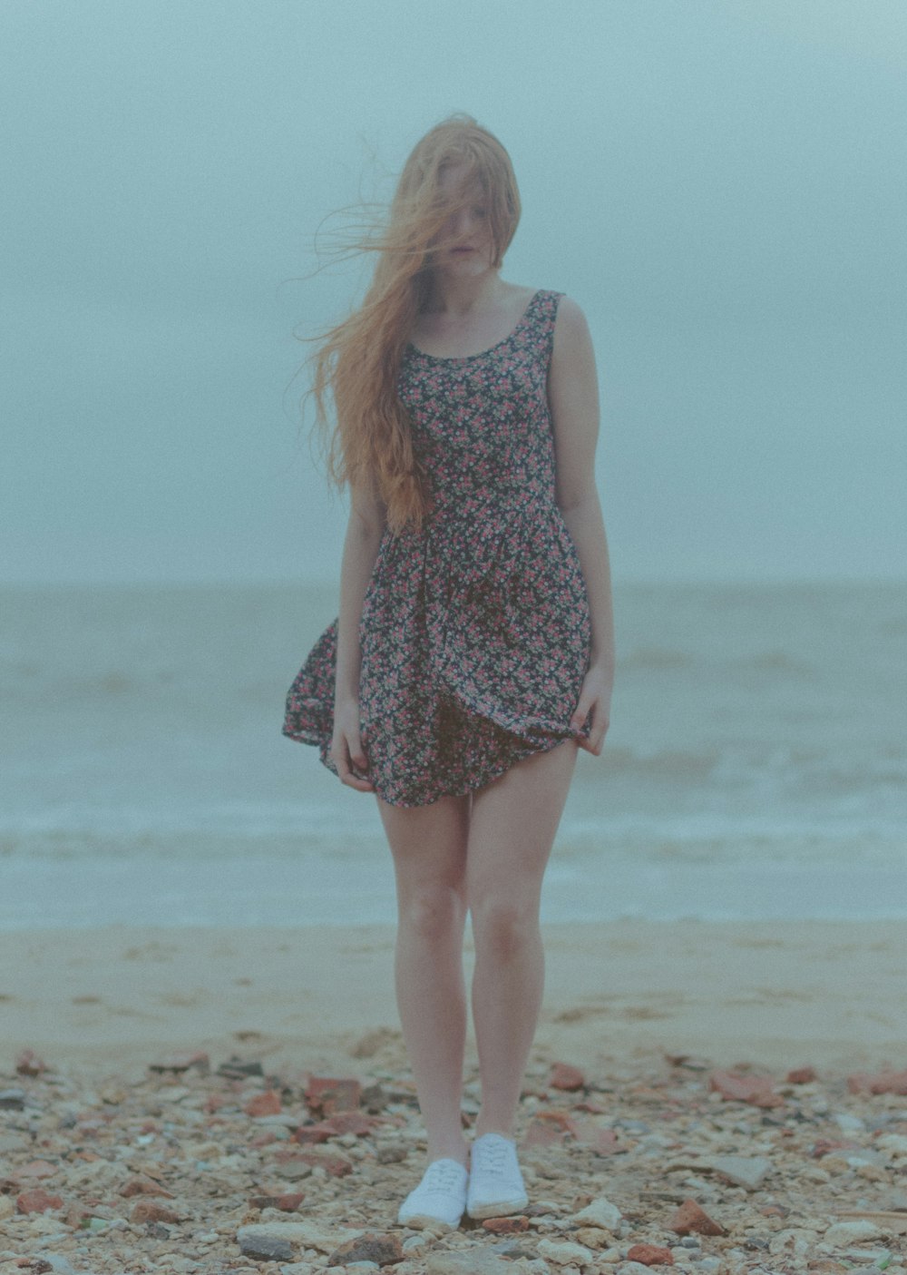 woman in white and black floral tank dress standing on beach during daytime