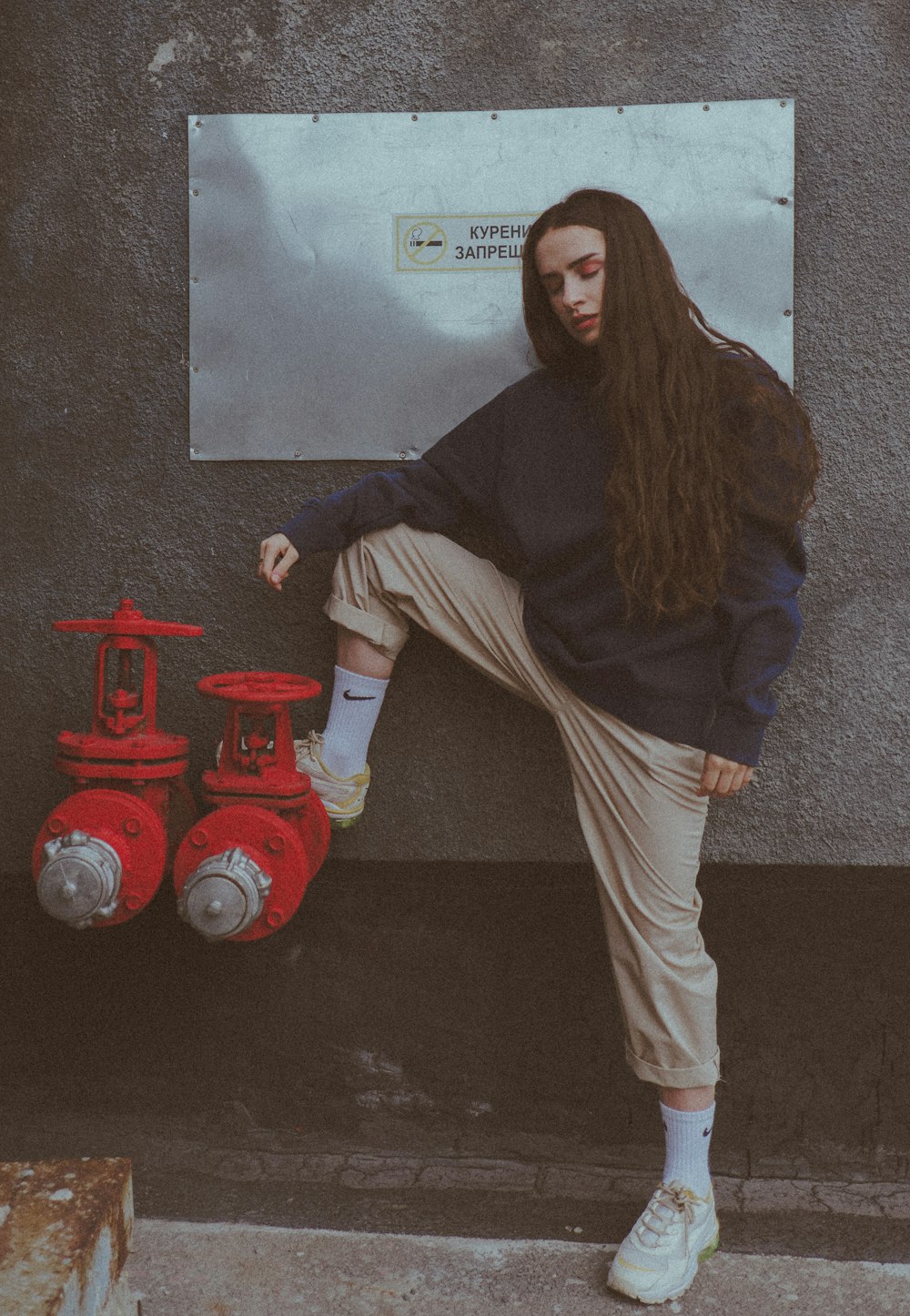 woman in brown hijab and brown long sleeve shirt standing beside red fire extinguisher