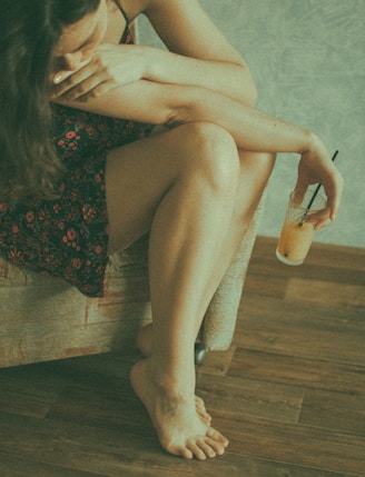 woman in black and red floral dress sitting on brown sofa