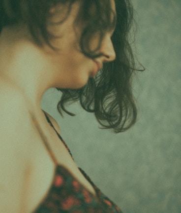 Elegant side profile showcasing silky black hair extensions styled in loose waves against a dark background.