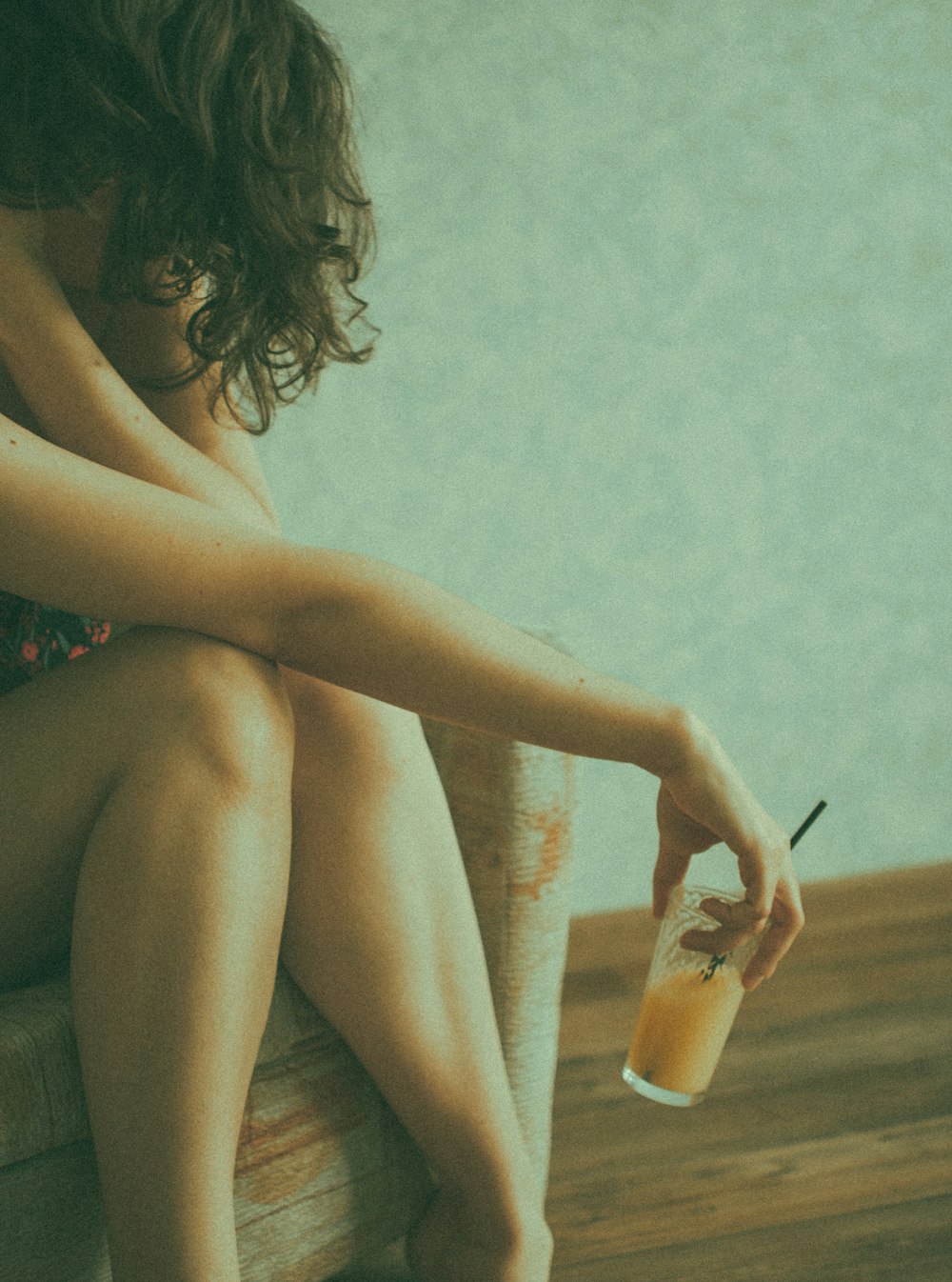 woman in red floral bikini holding clear drinking glass