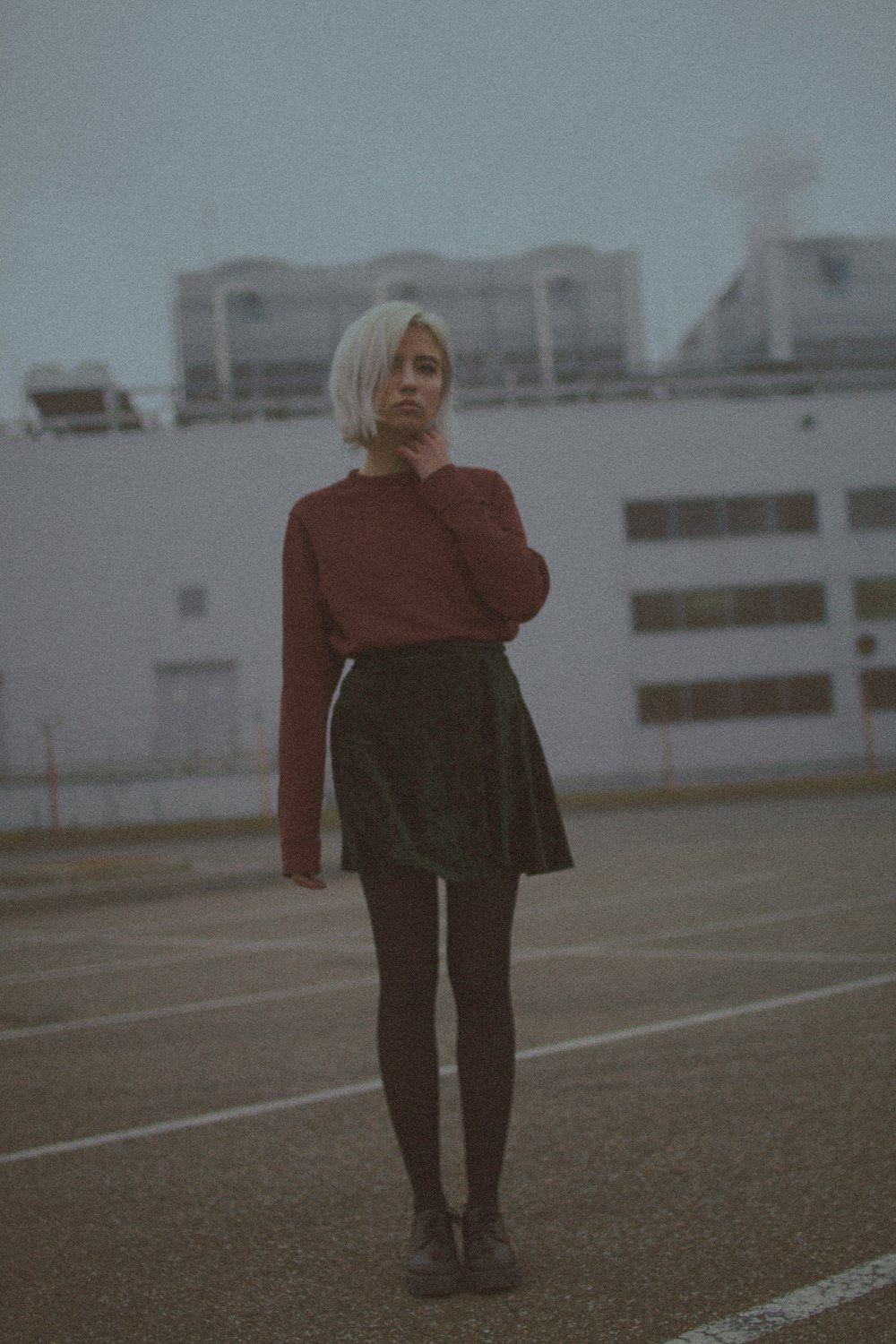 woman in red long sleeve shirt and black skirt standing on brown field during daytime