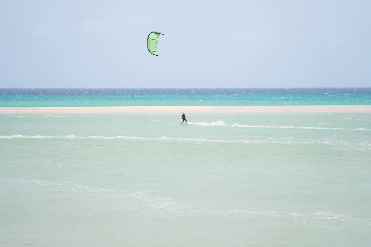 Kitesurfista navegando en aguas planas de una laguna costera