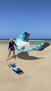 man in black shorts standing on blue and white inflatable ring on beach during daytime