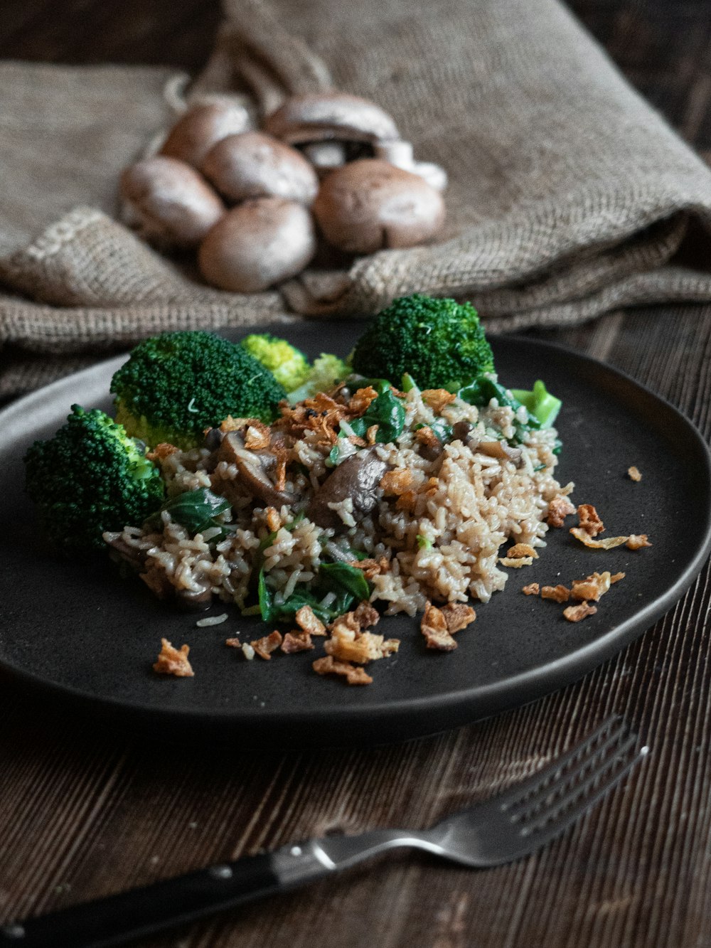 cooked rice with broccoli on black plate