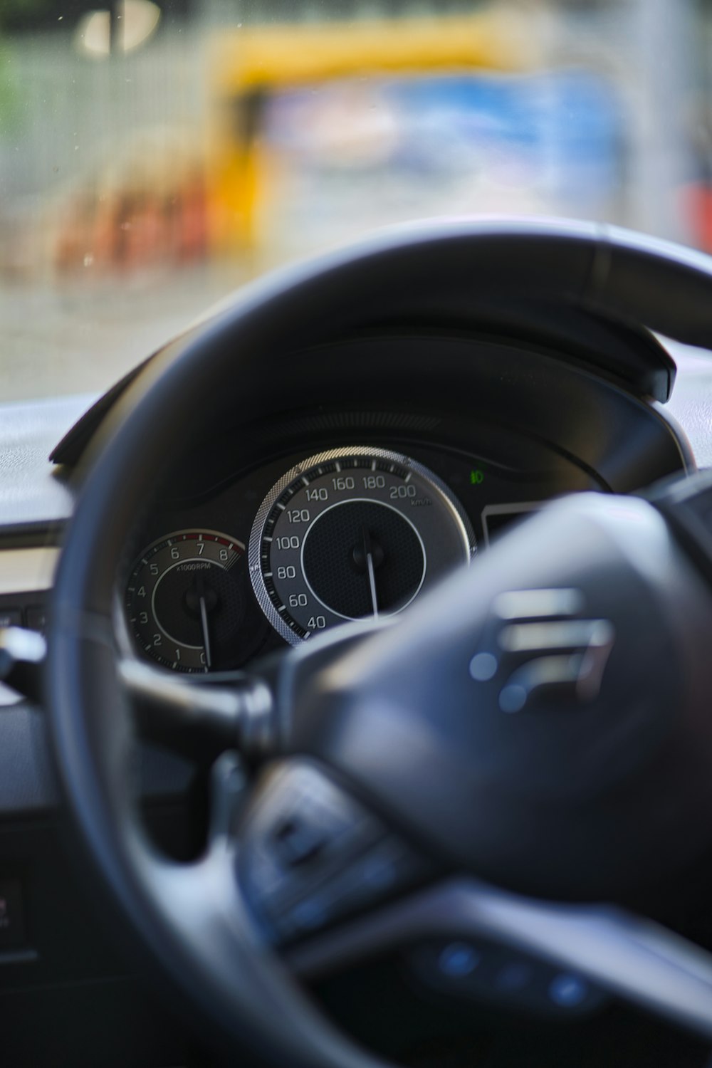 black car steering wheel and speedometer