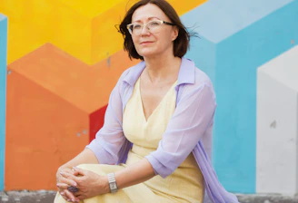 woman in white long sleeve shirt and pink cardigan sitting on concrete floor
