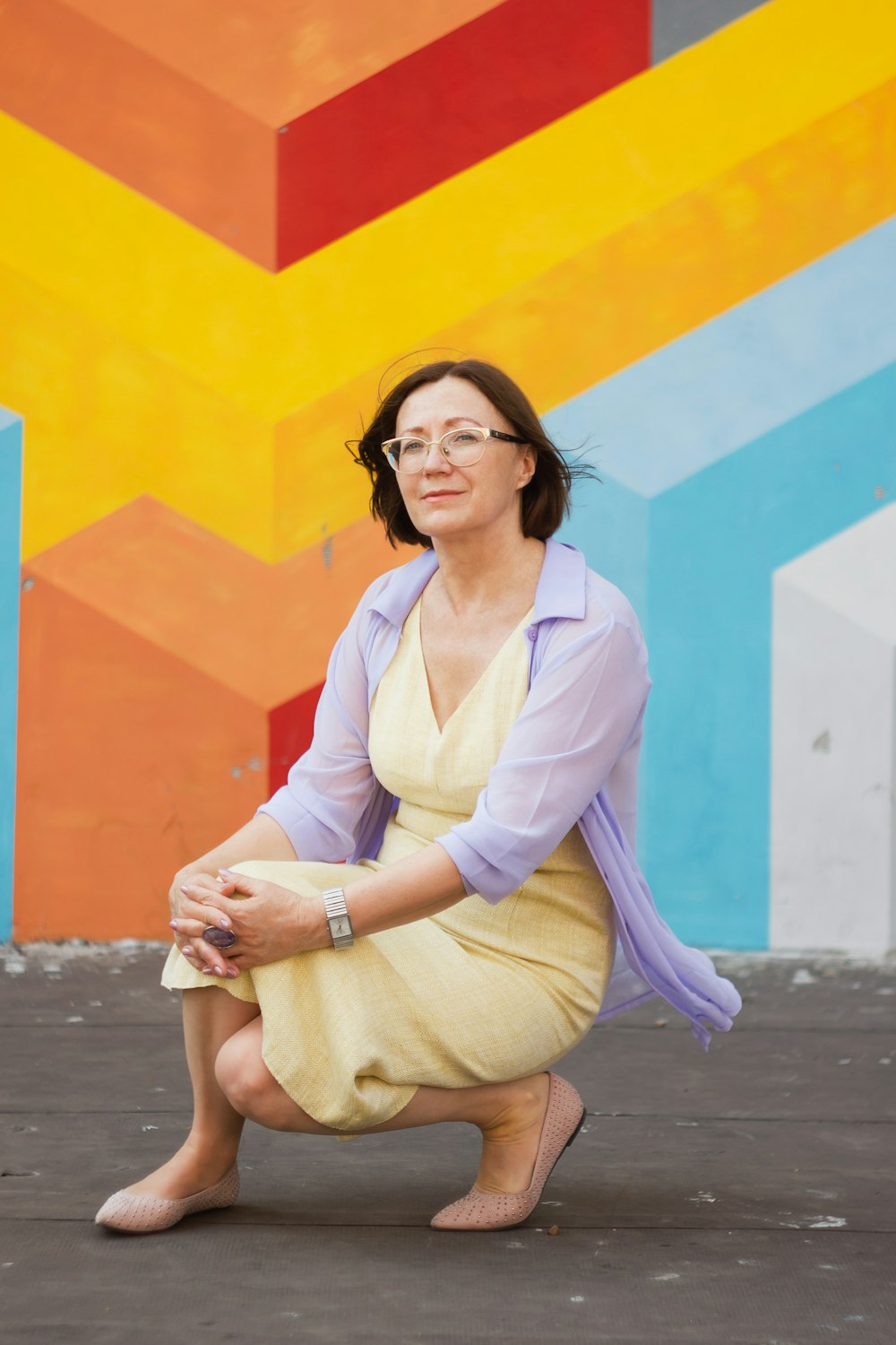 woman in white long sleeve shirt and pink cardigan sitting on concrete floor