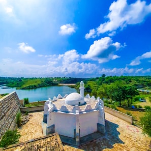white concrete building near green trees under blue sky during daytime