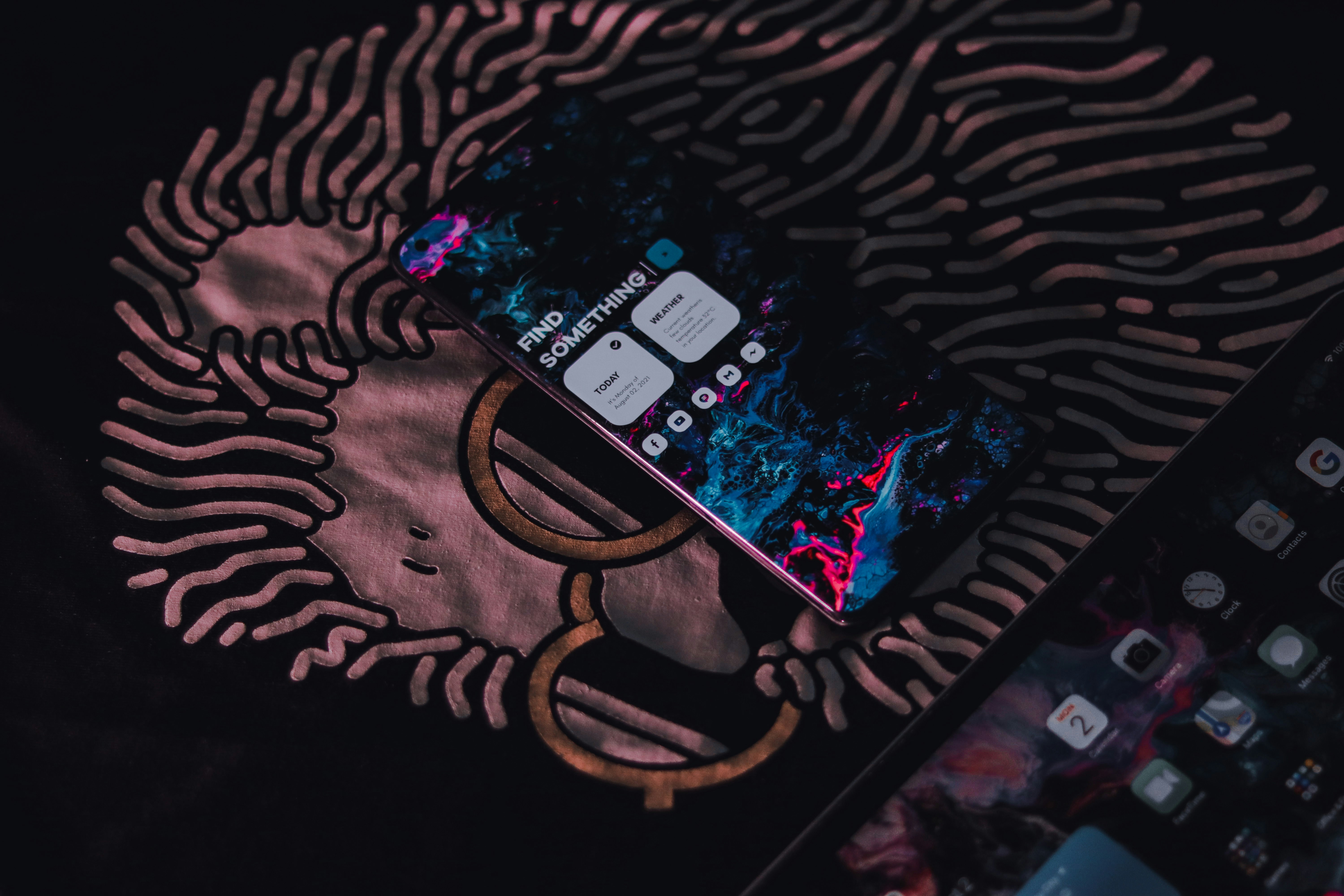 black android smartphone on black and brown textile