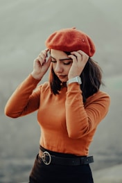 Close-up of a sleek, solid color beret styled with a casual autumn outfit.
