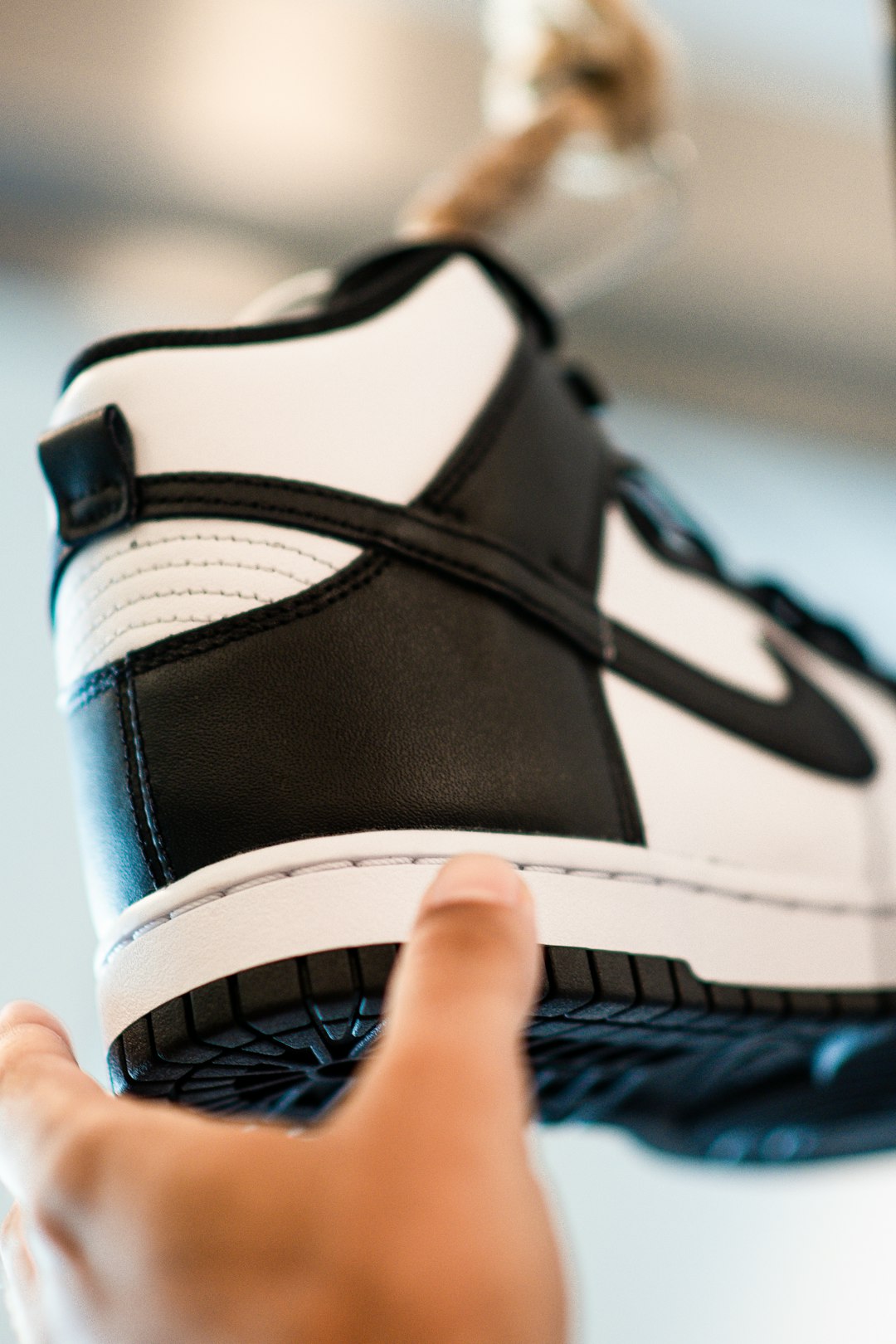 person holding black and white nike shoe