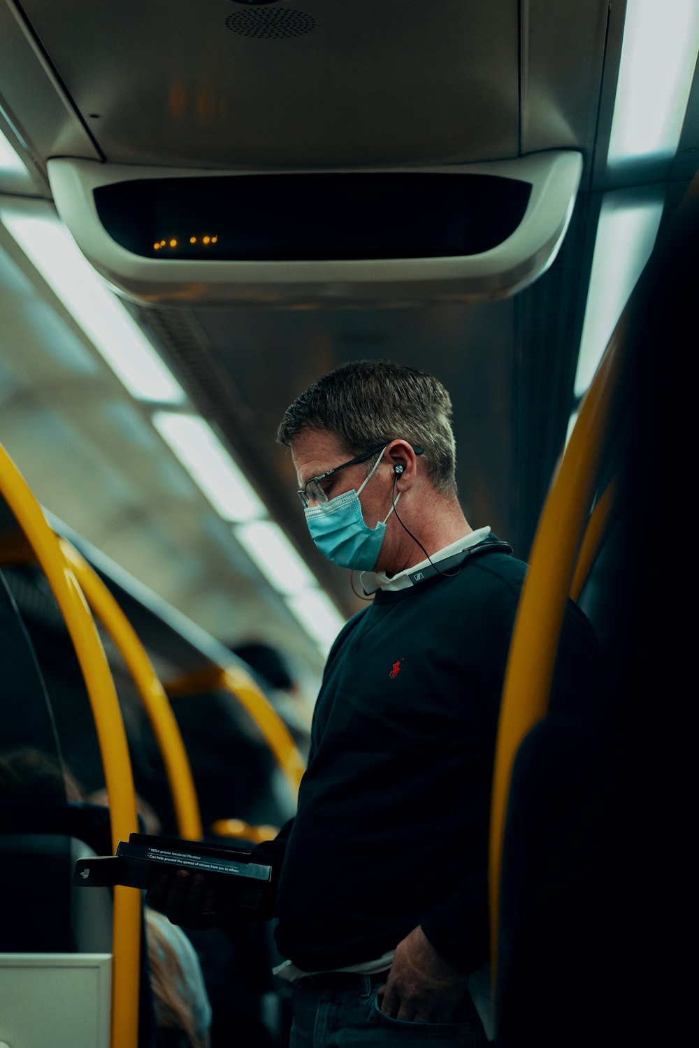 man in black jacket wearing sunglasses sitting inside train