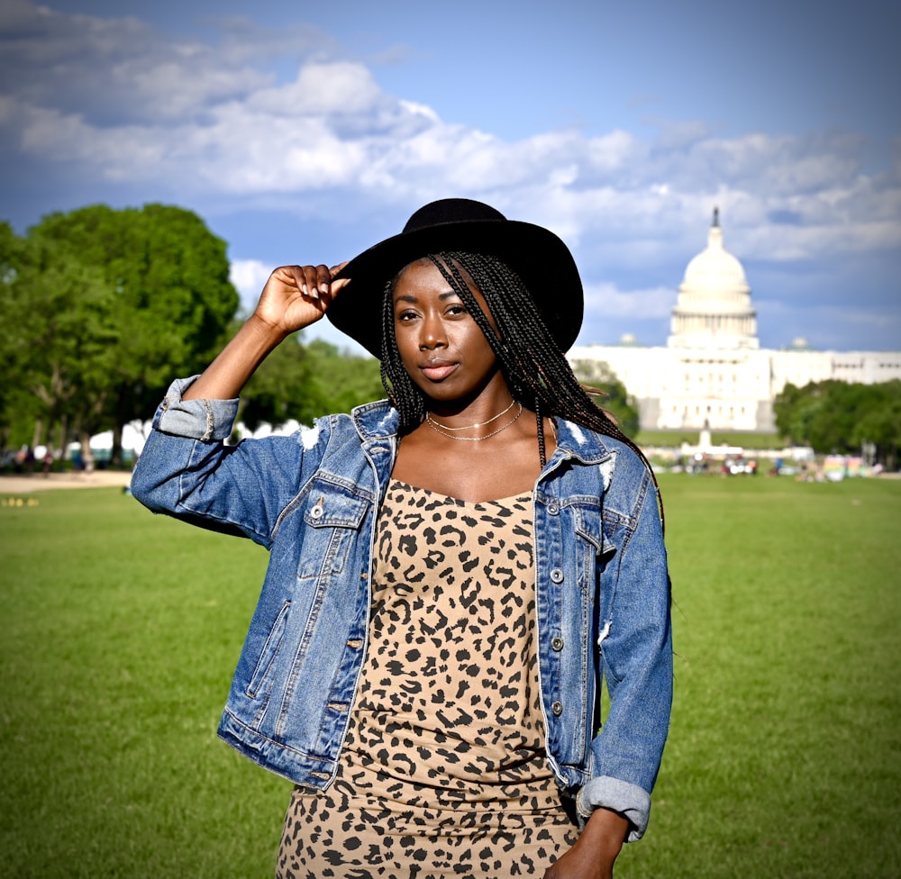 woman in blue denim jacket standing on green grass field during daytime