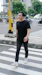 man in black crew neck t-shirt and black pants standing on sidewalk during daytime