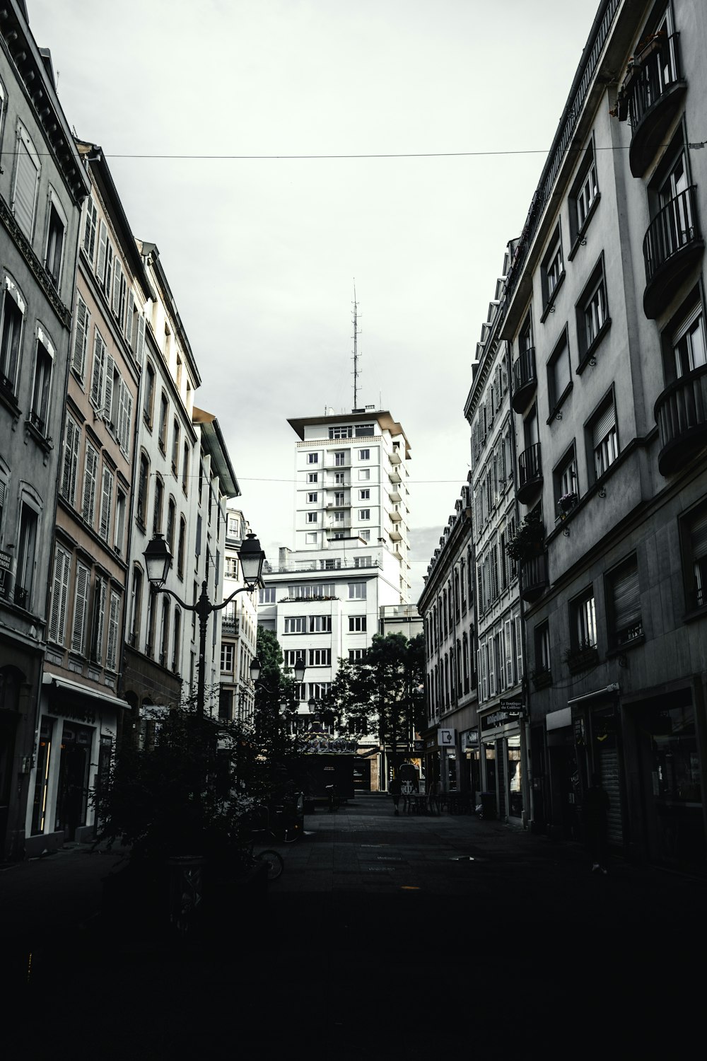 cars parked on side of the road in between of buildings during daytime