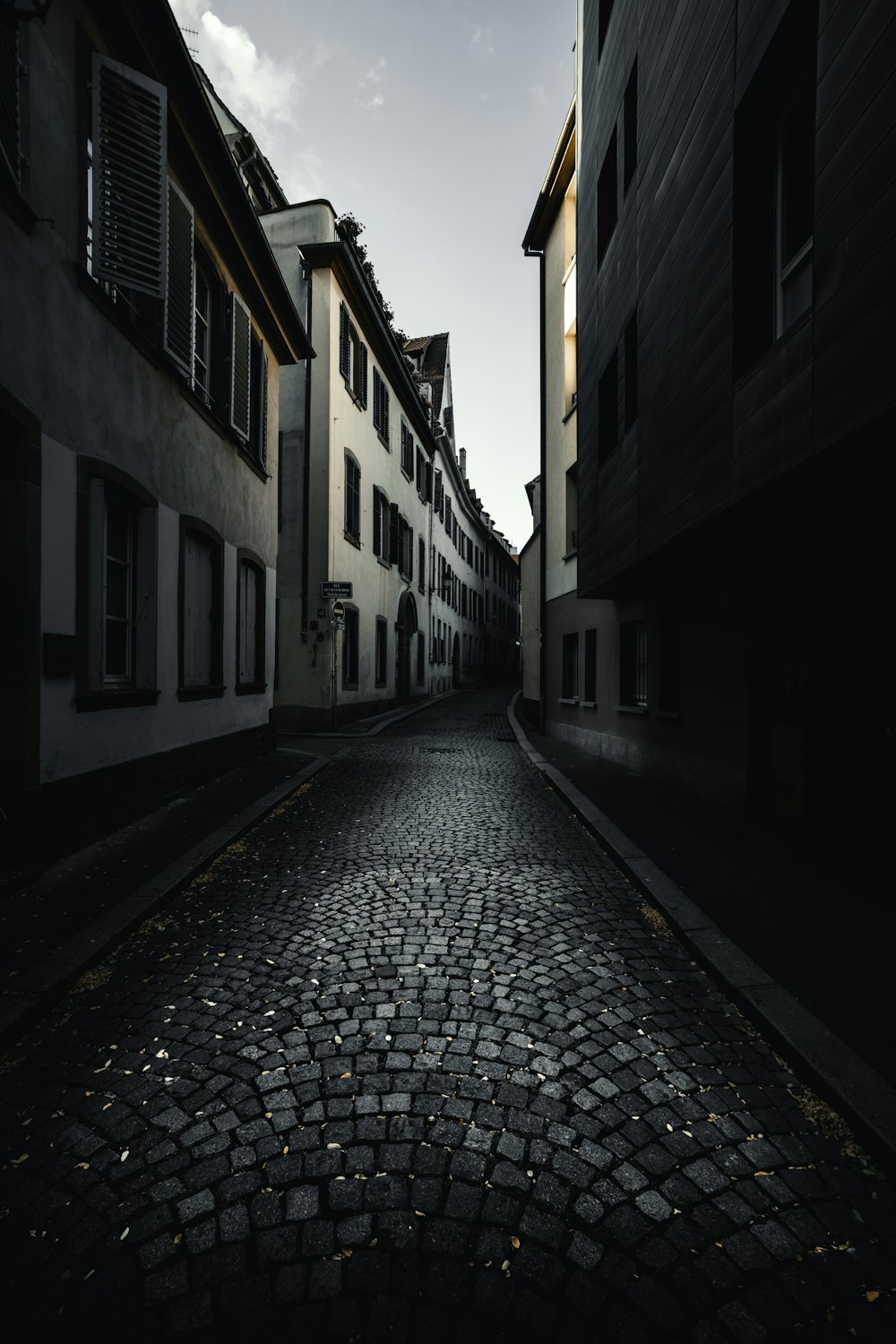 empty street between white concrete building during daytime