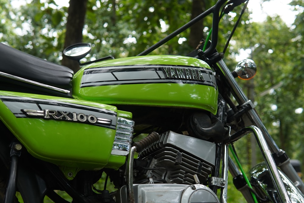 green and black motorcycle near green trees during daytime