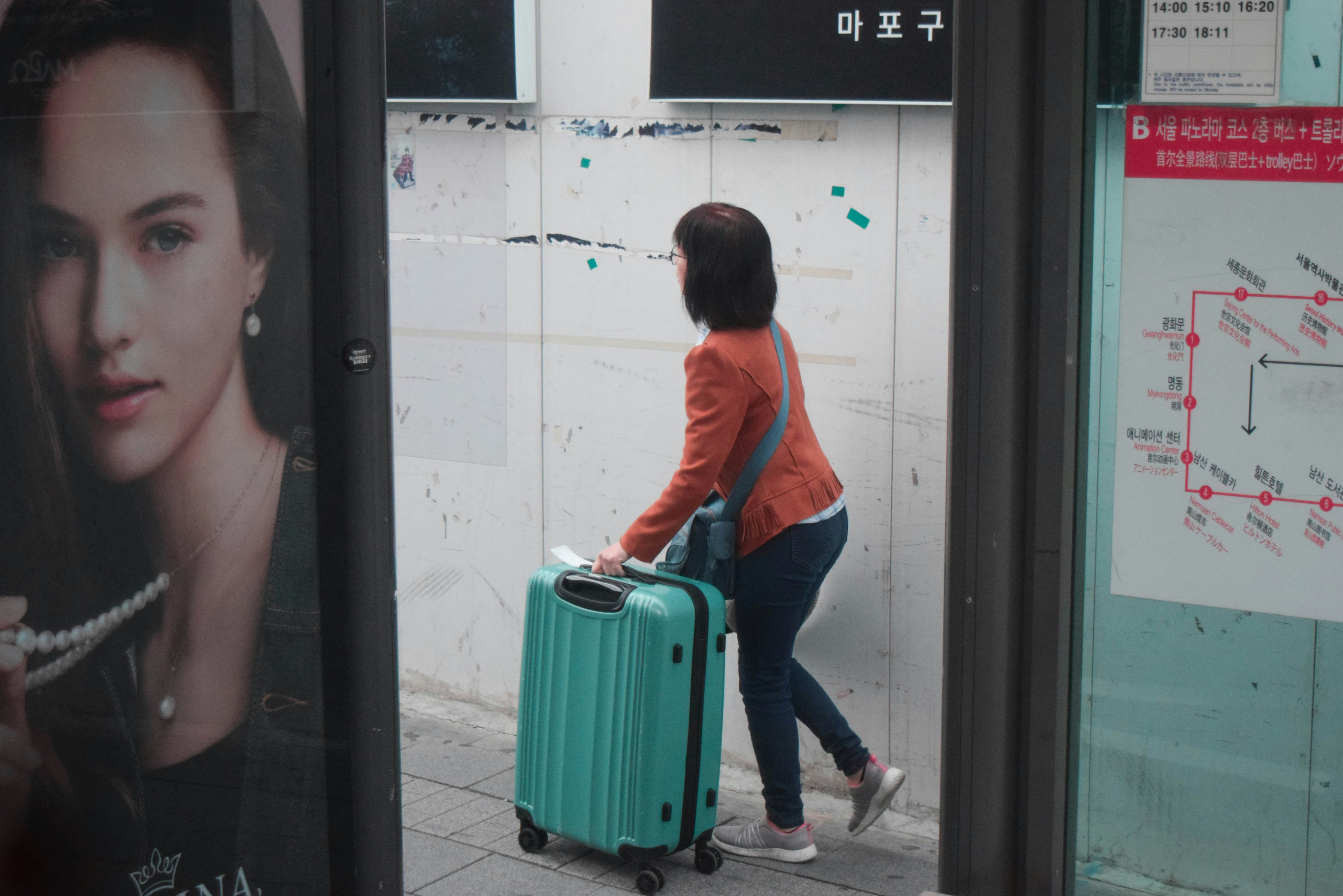 A tourist (?) rushes with her trolley bag