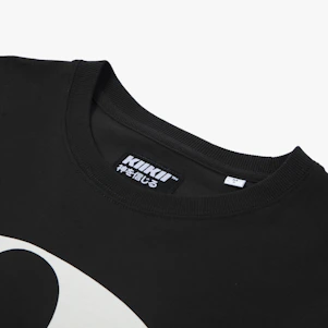 A close-up of a t-shirt featuring a minimalist badge logo in muted charcoal on a washed black fabric background.