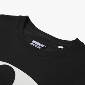 A close-up view of a black t-shirt featuring a neckline and a tag with the brand 'KIKII' printed on it, along with some Japanese characters. Part of a white graphic design is visible on the shirt's fabric.