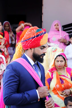 man in black suit jacket and orange and white bandana
