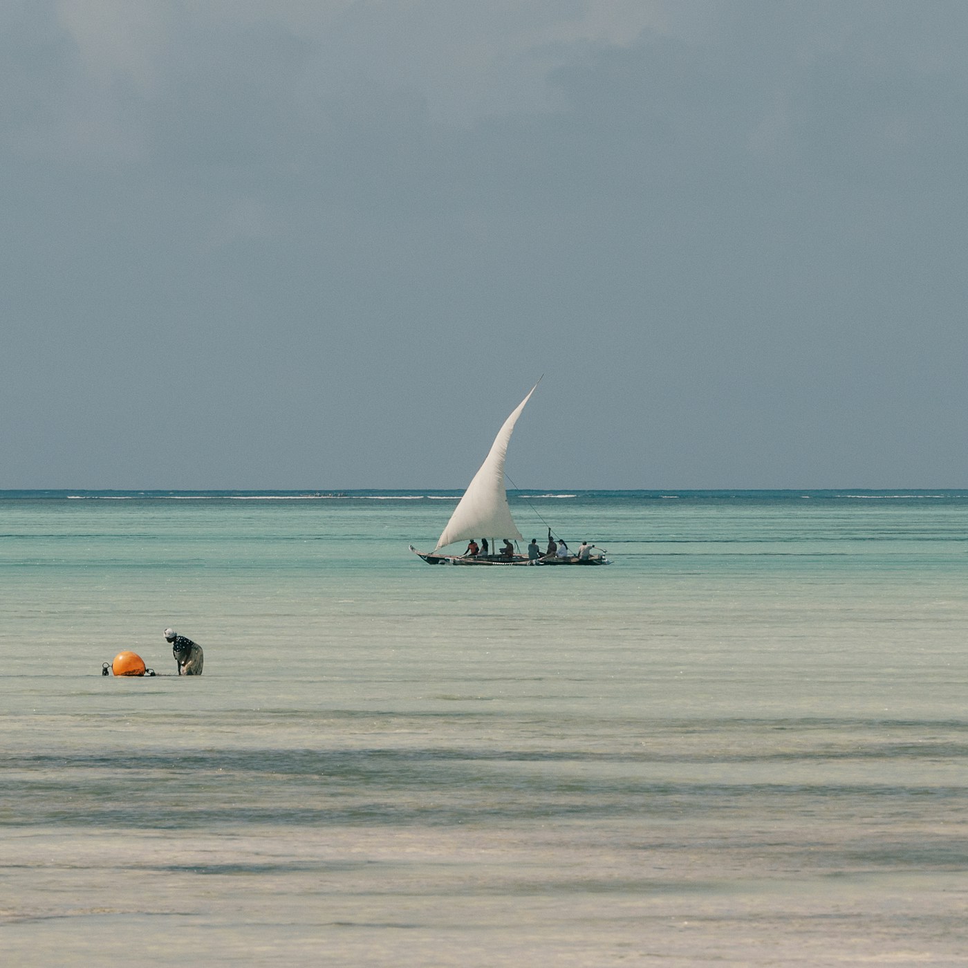 Sail on the horizon across the shallow flats