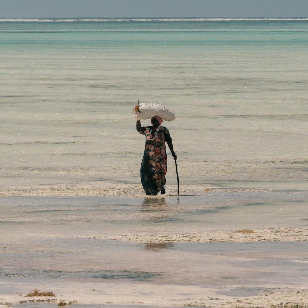 woman in black jacket standing on beach during daytime