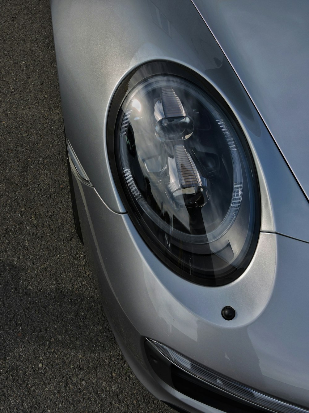 a close up of a silver sports car headlight