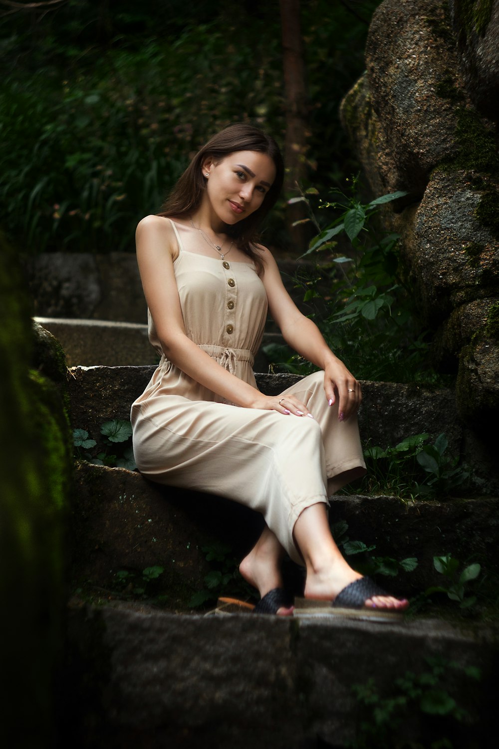 woman in brown sleeveless dress sitting on brown wooden bench