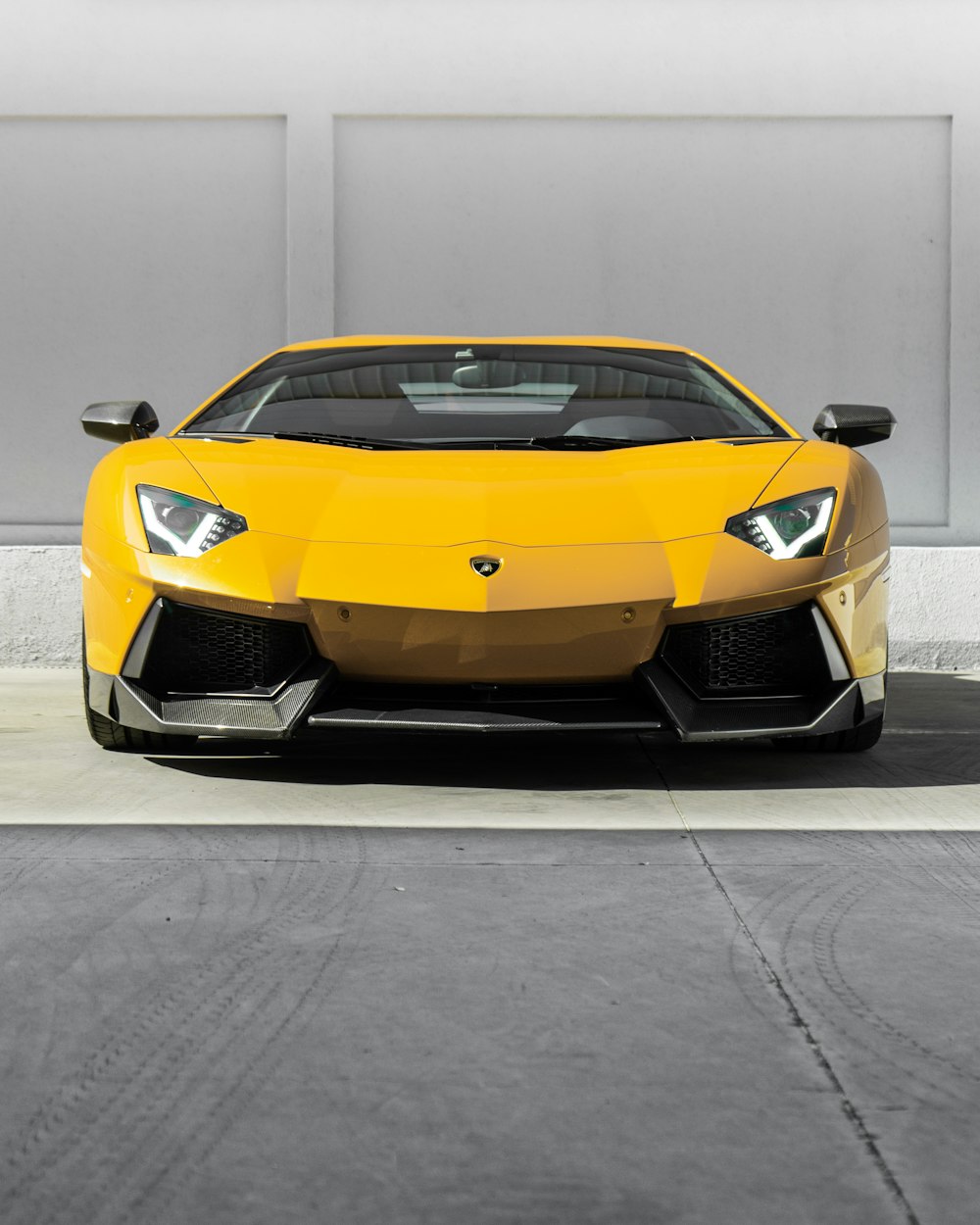 Gelber Lamborghini Aventador auf grauer Betonstraße geparkt