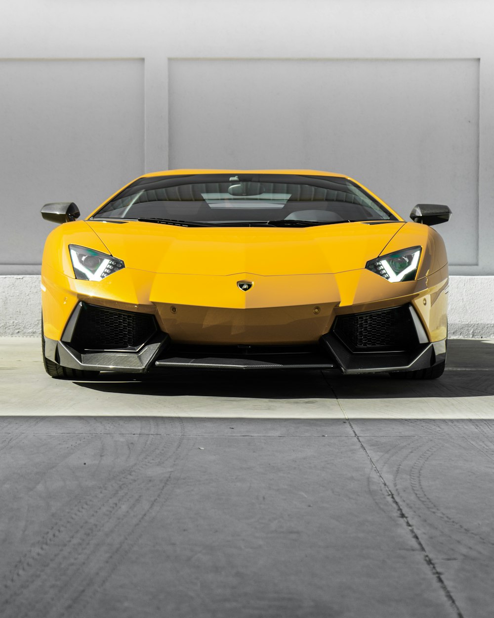 yellow lamborghini aventador parked on gray concrete road