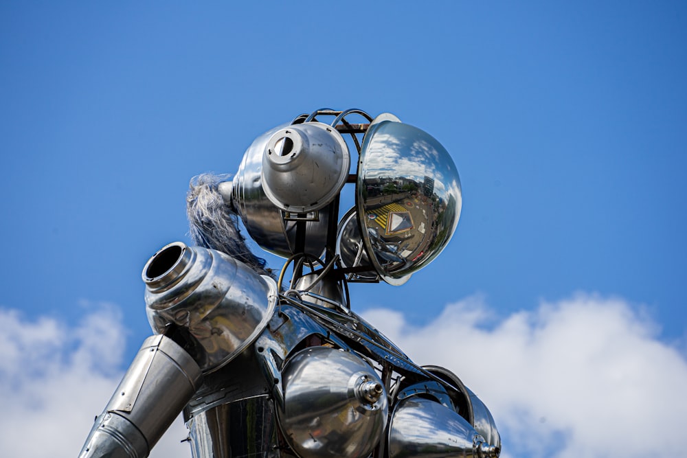 silver robot statue under blue sky during daytime