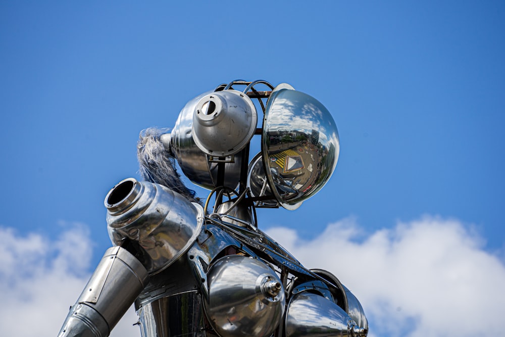 Statue de robot argenté sous le ciel bleu pendant la journée